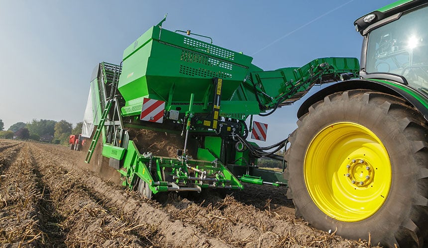 Offset potato harvester to keep wide low-pressure tyres on the tractor